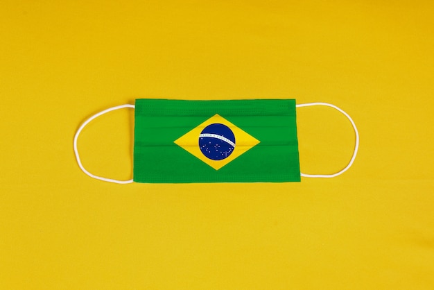 브라질 국기와 노란색 배경에 외과 마스크