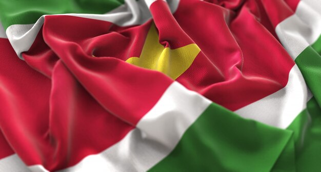 Суринамский флаг украшен красиво размахивая макровом крупным планом
