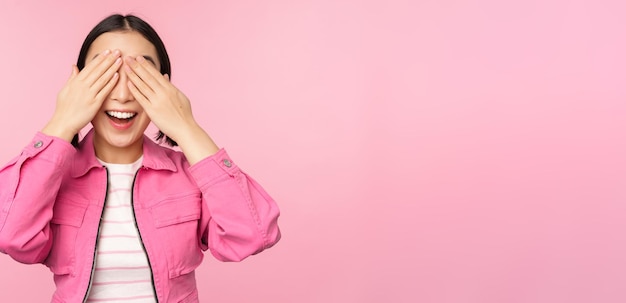 Surprise and celebration Portrait of asian happy girl close eyes waiting for gift anticipating something standing blindsided against studio background Copy space