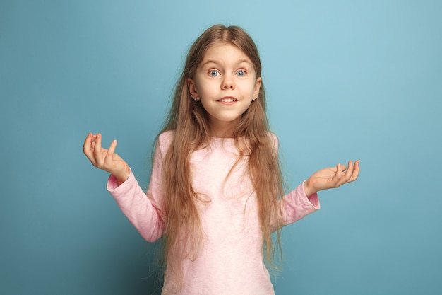 surprise, delight, happiness, joy, victory, success and luck. surprised teen girl on a blue studio background. Facial expressions and people emotions concept.