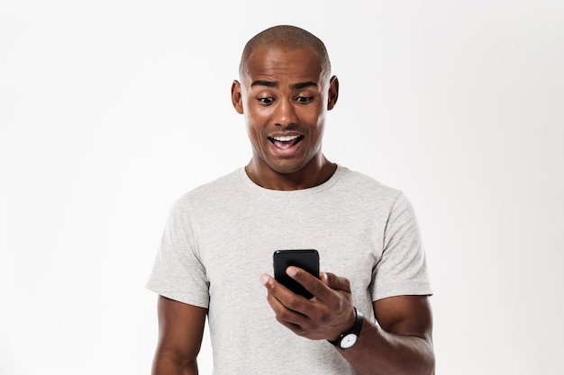 Surprised african man using smartphone