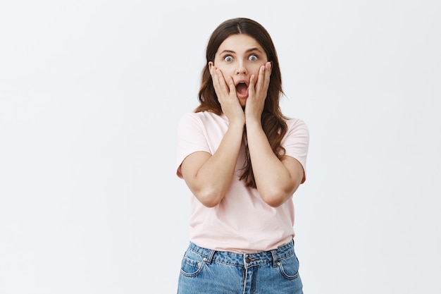 Surprised and amazed young brunette posing