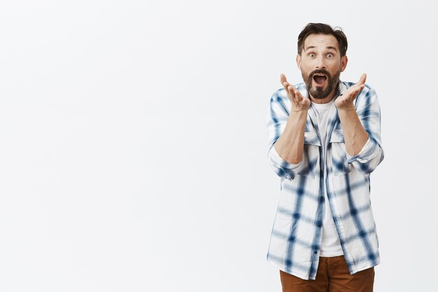 Surprised and amused bearded mature man posing