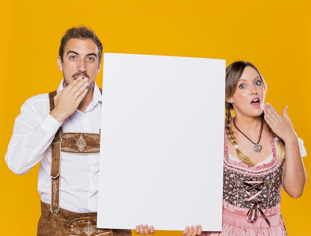 Surprised bavarian man and woman with mock-up