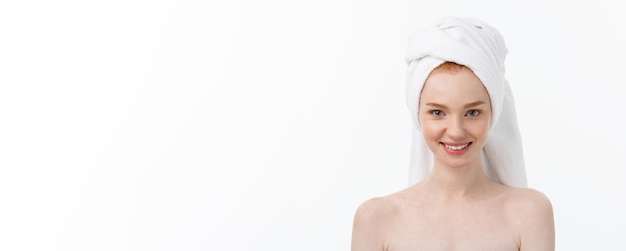 Free photo surprised beautiful young woman after bath with a towel on her head isolated on white background ski