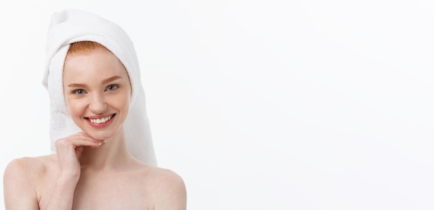 Free photo surprised beautiful young woman after bath with a towel on her head isolated on white background ski