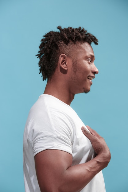 Free photo the surprised business afro-american man standing and looking blue background. profile view.