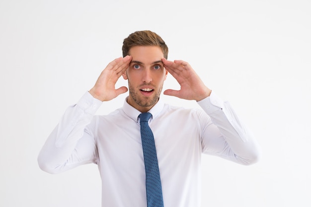 Surprised business man touching temples with his mouth open