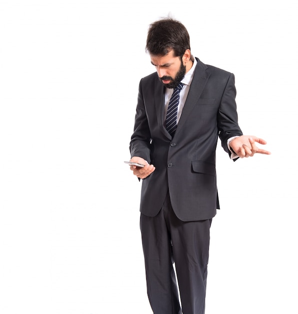 Surprised businessman talking to mobile over white background