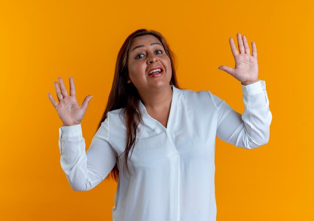 Free photo surprised casual caucasian middle-aged woman spreads hands isolated on yellow wall