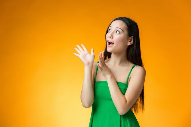 The surprised Chinese girl on yellow background