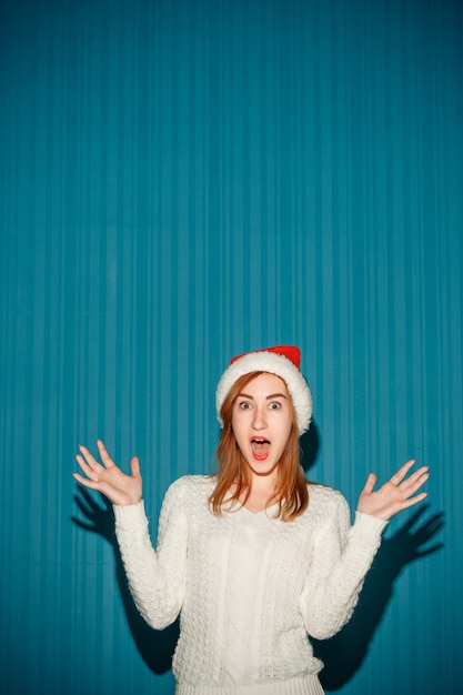 Удивленная рождественская женщина в шляпе санта-клауса