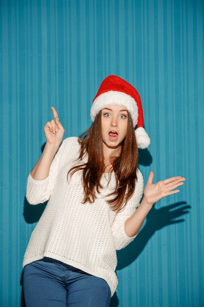 サンタの帽子をかぶって驚いたクリスマス女性