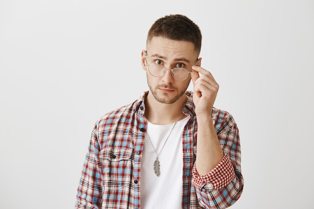 Free photo surprised and confused young guy with glasses posing