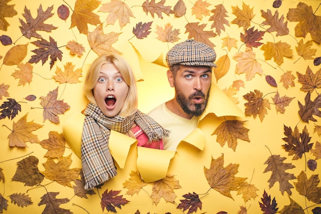 Surprised couple on autumn clothes discounts man with beard and an attractive girl in yellow backgro...