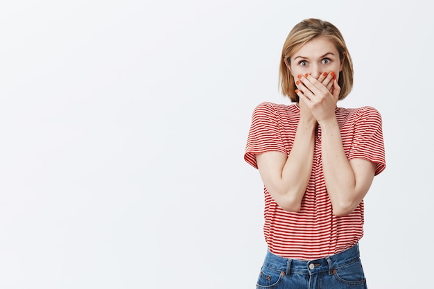 Ragazza graziosa curiosa sorpresa ha chiuso la bocca e guardando a destra