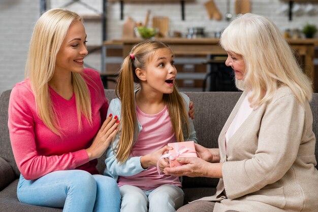 Surprised daughter receiving a gift from her grandmother