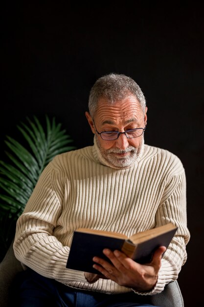 Удивленный пожилой мужчина читает книгу