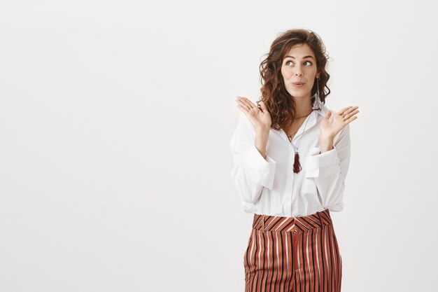 Surprised enthusiastic woman claps her hands and looks left impressed