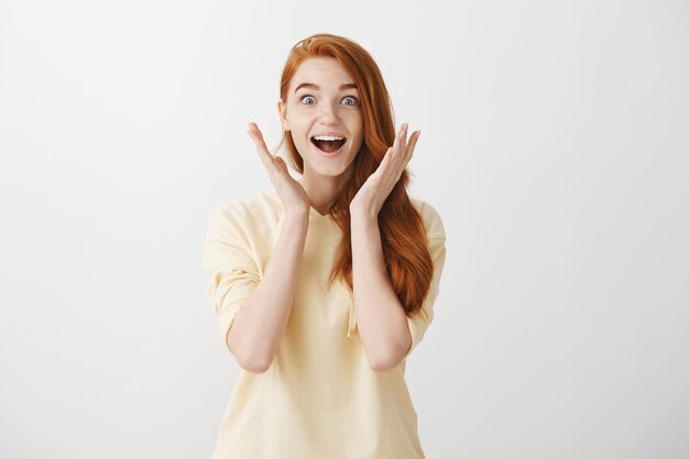 Surprised and excited pretty redhead girl react to awesome news