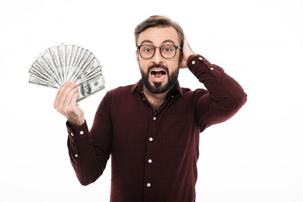 Surprised excited young man standing isolated