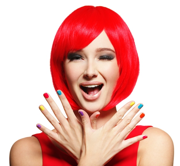 Surprised face of an young pretty woman  with bright red hairs and multicolor nails.