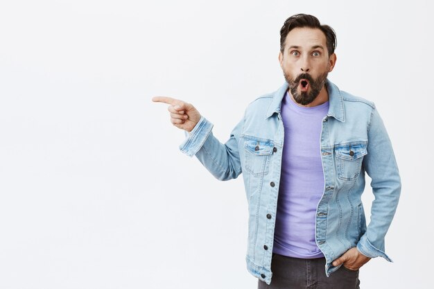 Surprised and fascinated bearded mature man posing