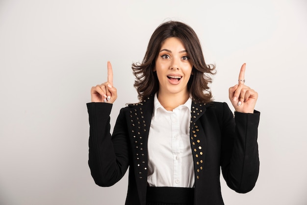 Surprised female worker pointing at upside