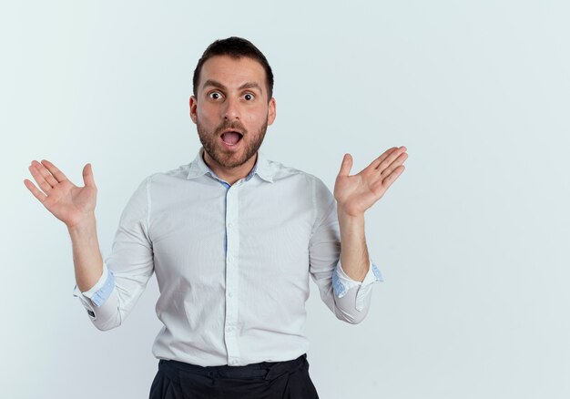 Surprised handsome man stands with open hands isolated on white wall