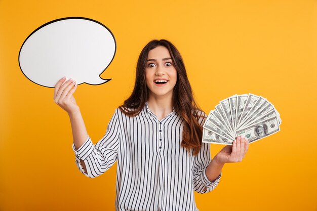 Surprised happy brunette woman in shirt holding blank speech bubble