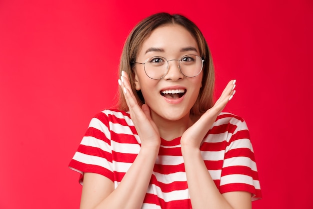 La ragazza bionda asiatica carina e felice sorpresa si rende conto che è stata fortunata sorridendo ampiamente gesticolando scuotendo...