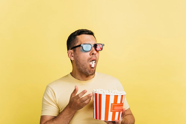 Surprised man eating popcorn with copy space