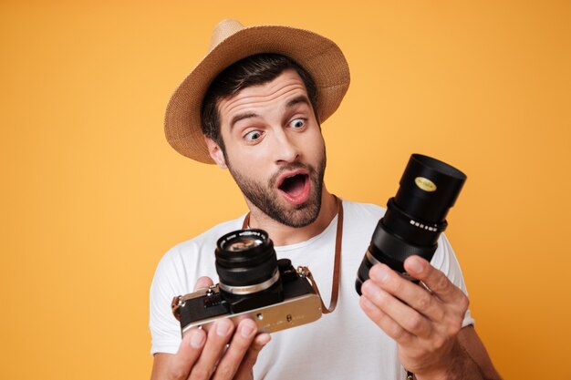 Surprised man looking at big lens for camera