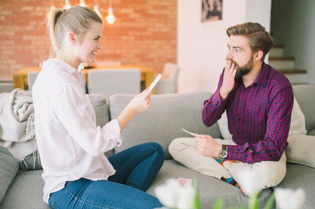 Surprised man playing cards with girlfriend