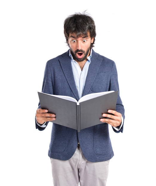 Free photo surprised man reading a book over white background