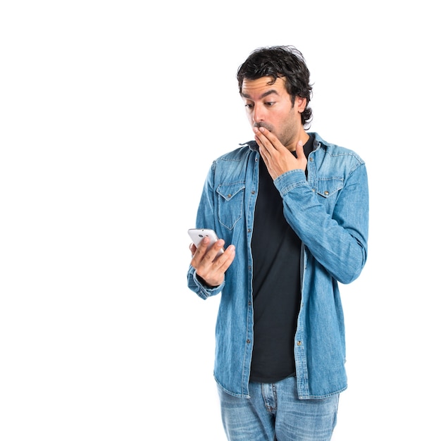 Surprised man talking to mobile over white background