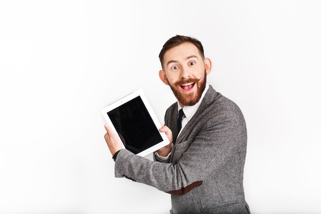 Surprised man with red beard works with tablet