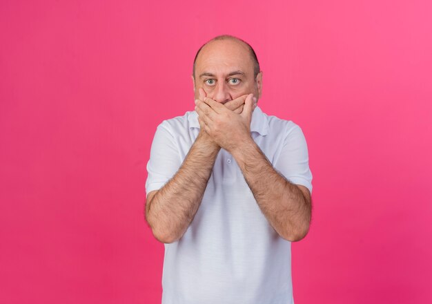surprised mature businessman covering mouth with two hands