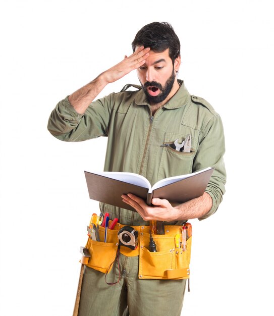 Surprised mechanic reading book