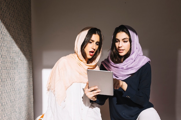 Surprised muslim women with tablet