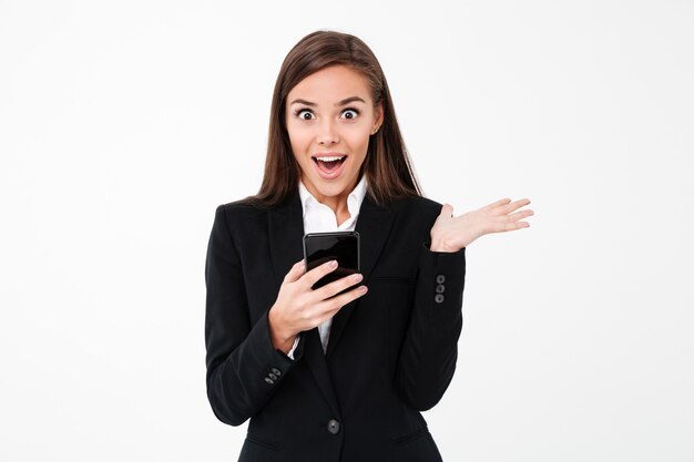 Surprised pretty businesswoman chatting by phone.