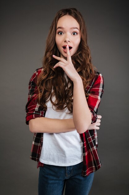 Surprised pretty young woman standing with opened mouth