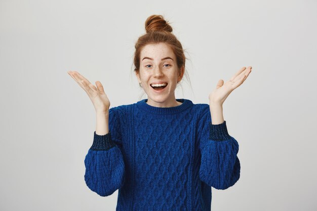 Surprised relieved happy redhead girl, raising hands up amazed