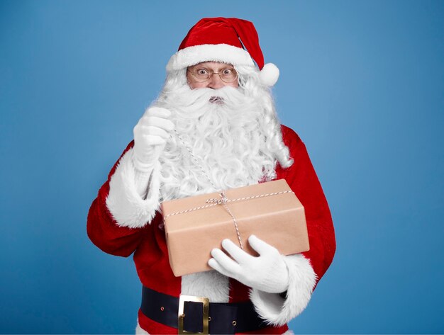 Surprised santa claus opening gift