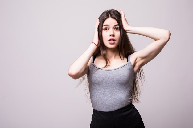 Surprised shocked young woman standing with opened mouth