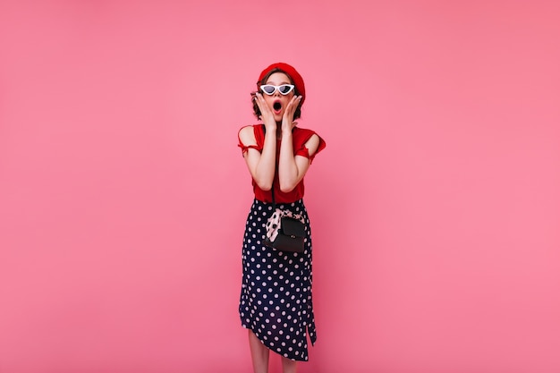 Ragazza francese dai capelli corti sorpresa in posa. foto dell'interno della donna alla moda in gonna lunga che esprime stupore.