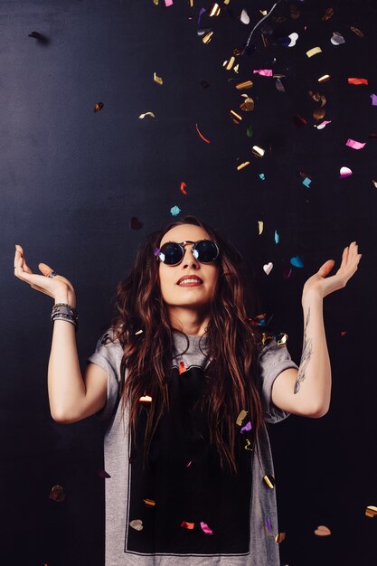 Surprised smiling woman surrounded by confetti