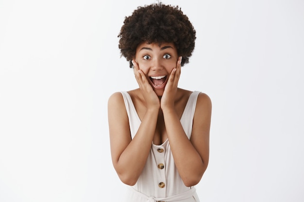 Surprised stylish girl posing against the white wall