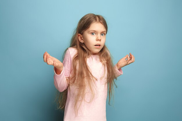 The surprised teen girl on a blue studio