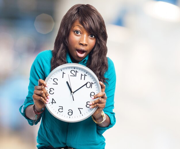 Surprised teen showing a clock